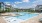 Beautiful outdoor resort-style pool at Colina Weho featuring tanning ledges, lounge chairs, cabanas, and modern landscaping.