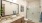 Elegant bathroom at Colina Weho apartments featuring a granite double vanity, glass shower, and sleek finishes.